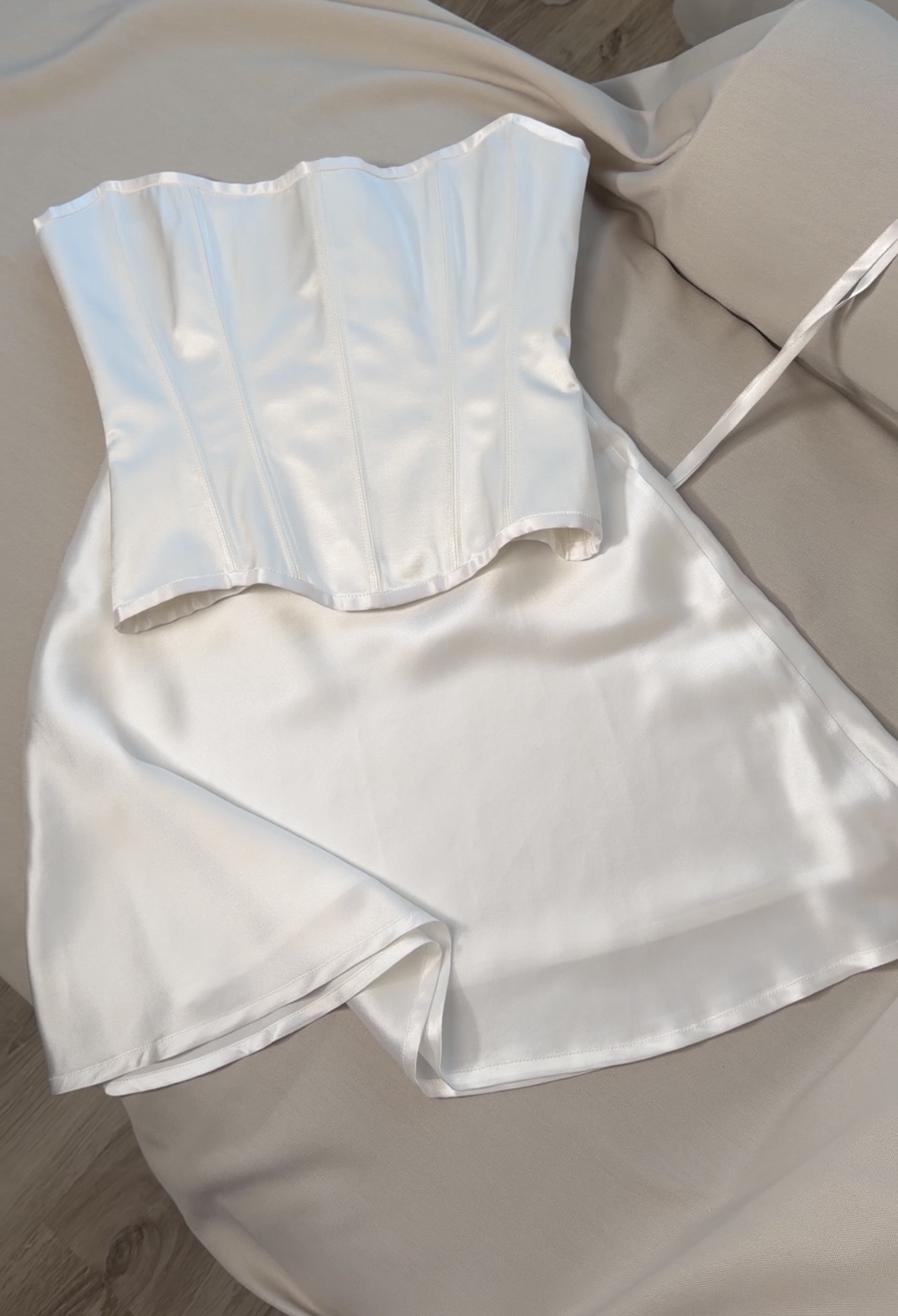 Ivory silk corset, separate mini skirt and matching scarf laid out together