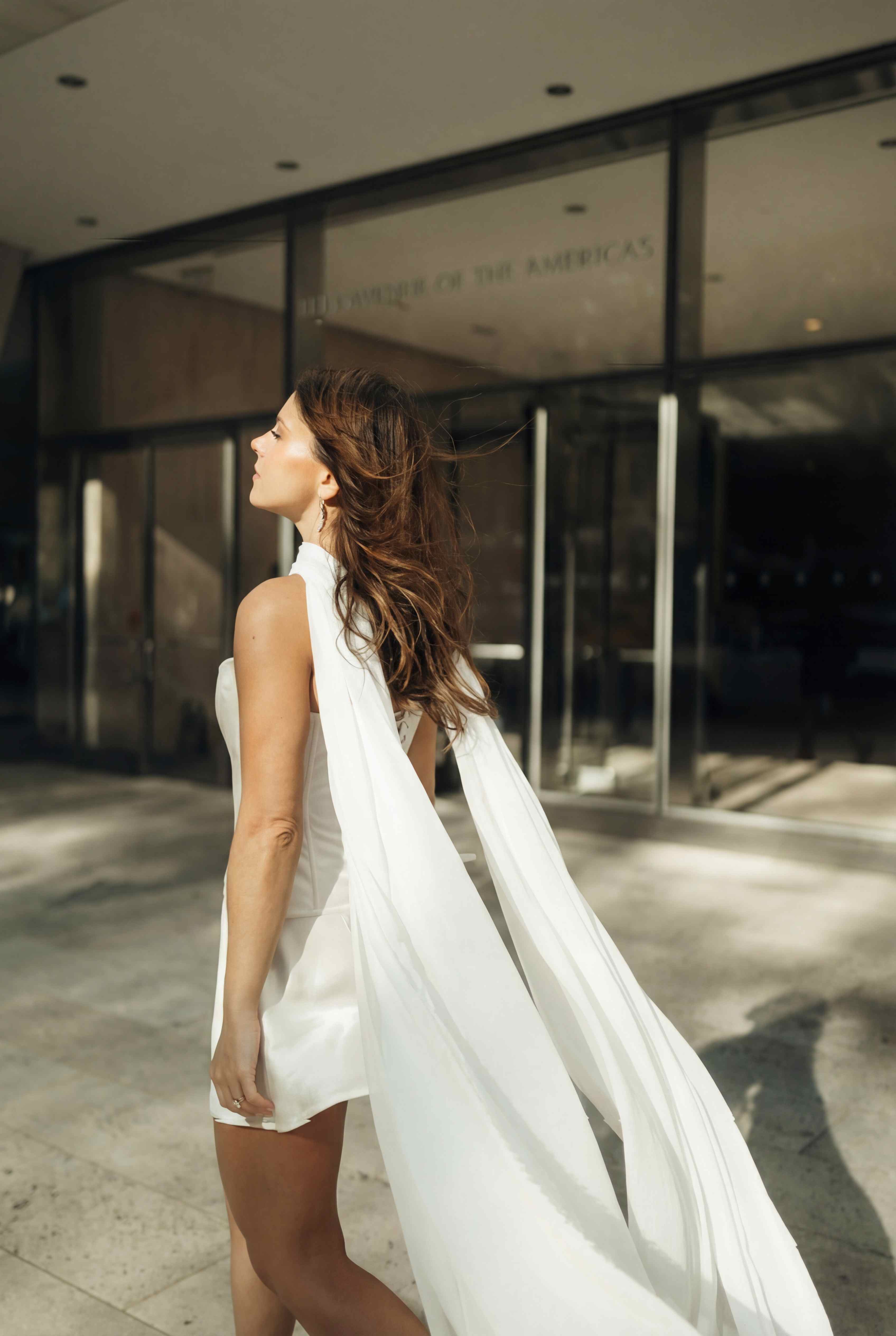 Long ivory scarf falling down the back of a corset and mini skirt outfit